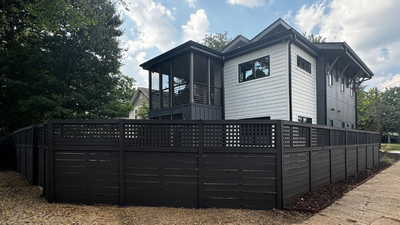 A house with a professionally painted fence that reflects Raleigh’s local style and trend, completed by an exterior painting specialist.