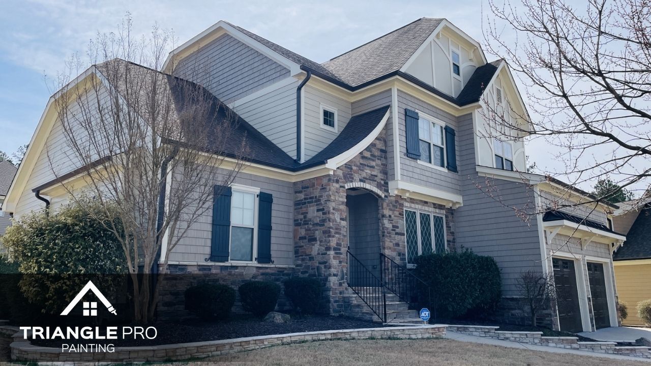 A two-story home with a sharp, freshly painted exterior featuring stone and siding details