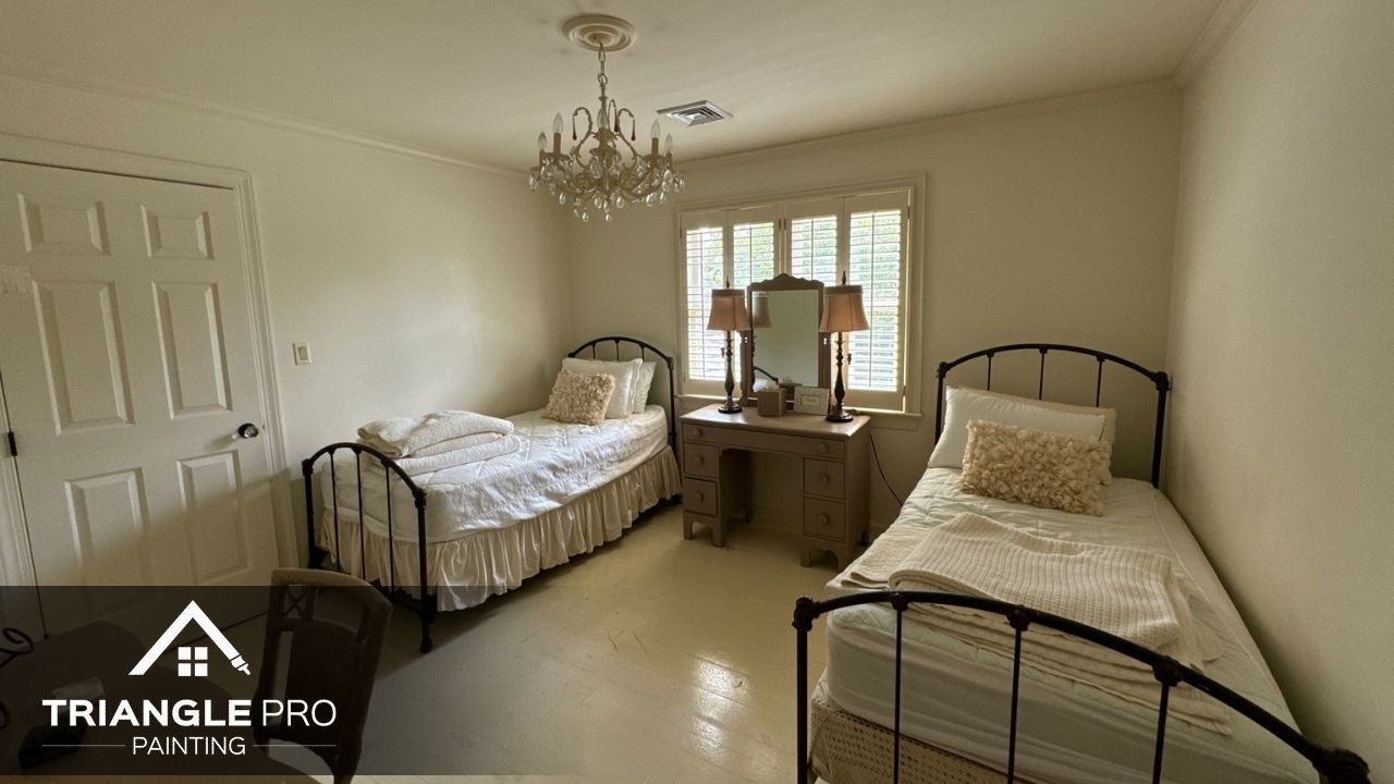 This photo shows a freshly painted bedroom interior with twin beds and soft beige walls by Triangle Pro Painting in Madonna Acres Raleigh NC.