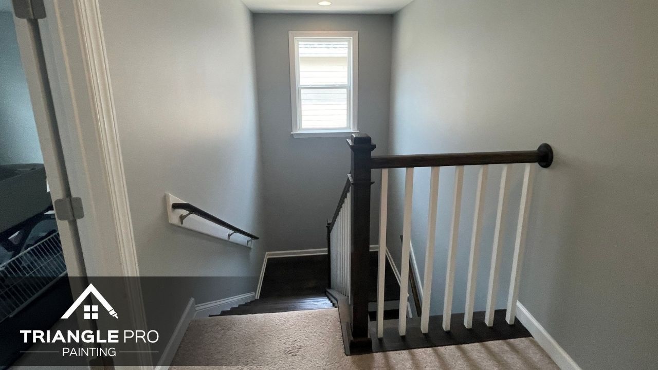 This image shows a freshly painted stairway and hallway interior in Madonna Acres, Raleigh, NC by Triangle Pro Painting.