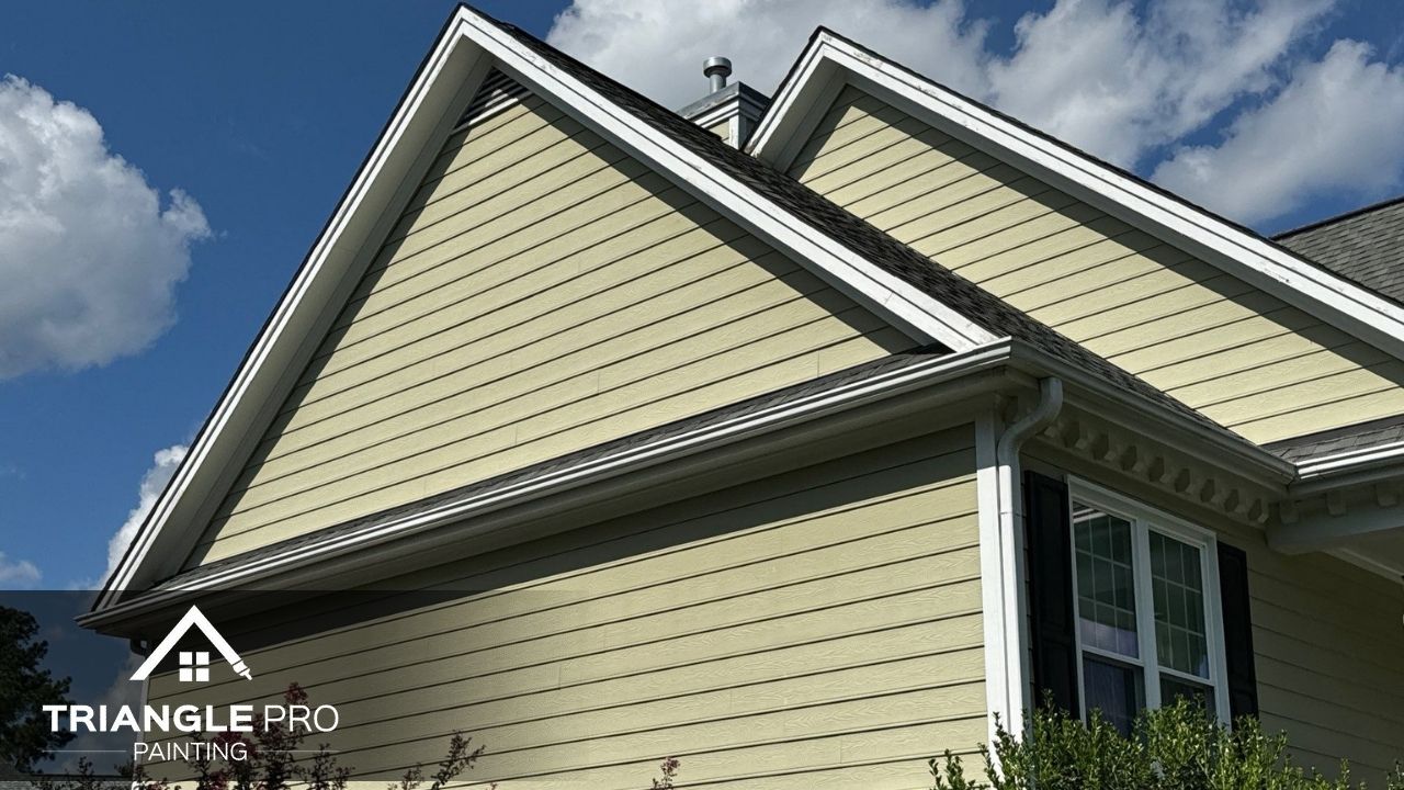 This close-up image displays fresh yellow exterior siding with white trim work, part of Triangle Pro Painting’s residential exterior project in Madonna Acres Raleigh NC.