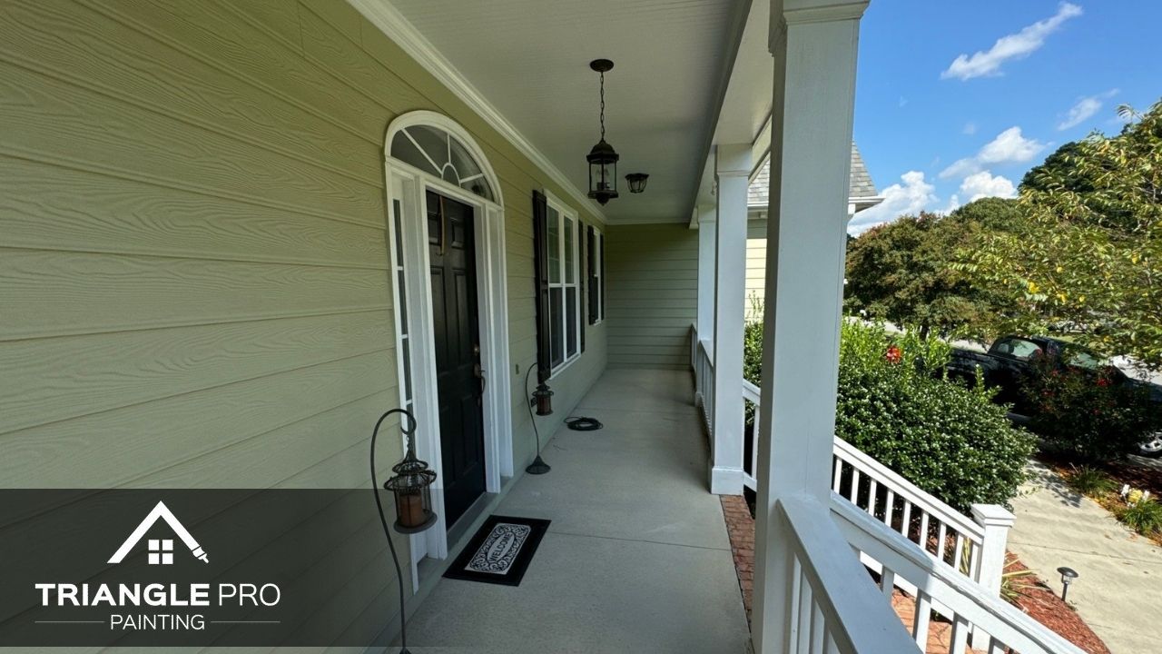 This image features a freshly painted porch with smooth siding, dark doors, and crisp white trim in Madonna Acres Raleigh NC by Triangle Pro Painting.