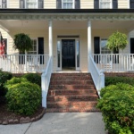 Painter applying moisture-resistant paint to a Raleigh home exterior