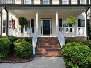 Painter applying moisture-resistant paint to a Raleigh home exterior