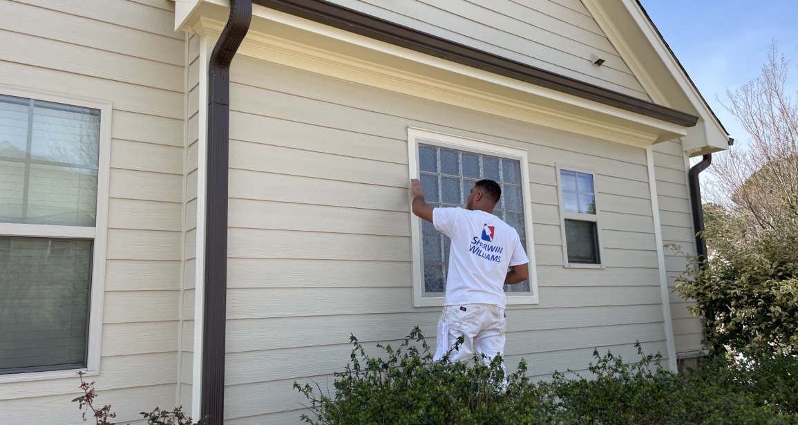 Painter preparing interior walls before applying new paint in a Raleigh home