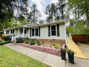 Professional painter applying exterior paint to a Raleigh home in mild weather