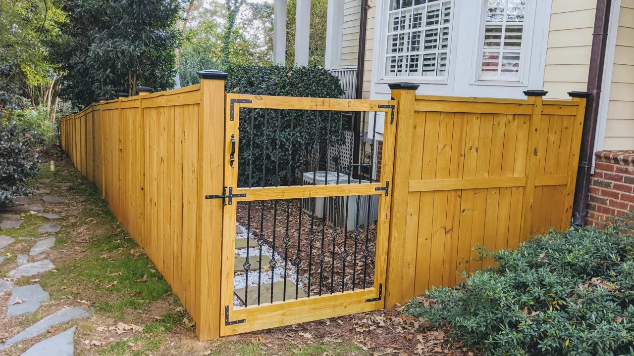 A fence in Raleigh, NC that is painted with brown stain.