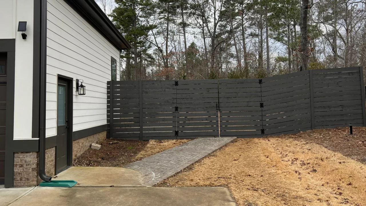 A fence in Raleigh, NC that is painted with black paint.