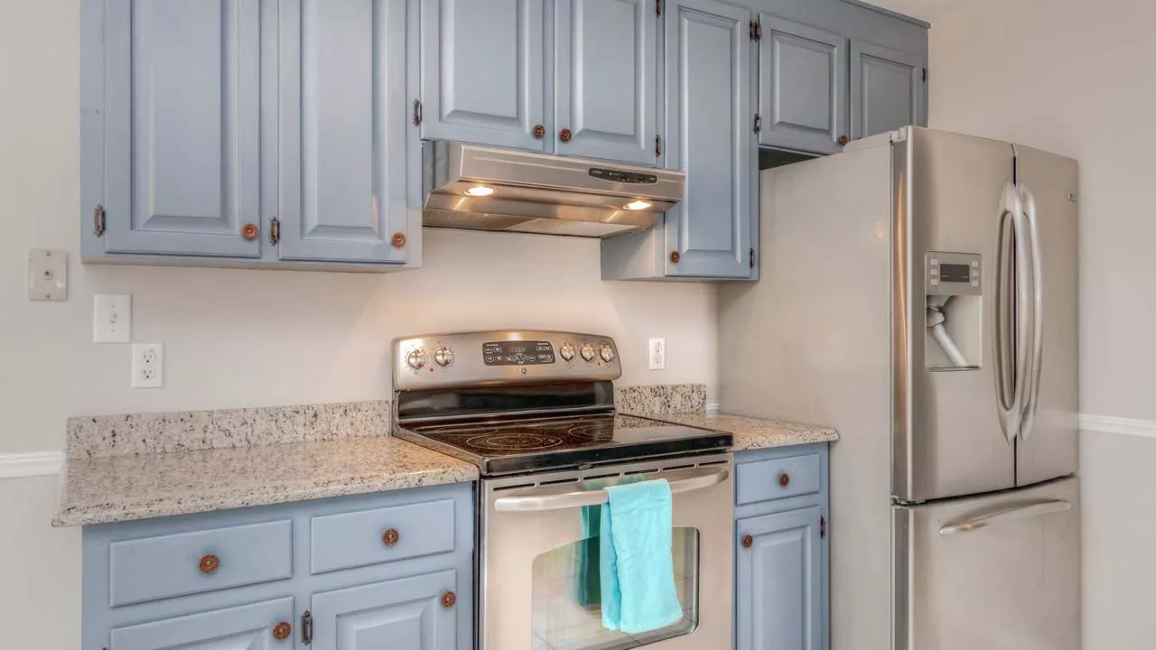Kitchen with newly painted cabinets and marble counter