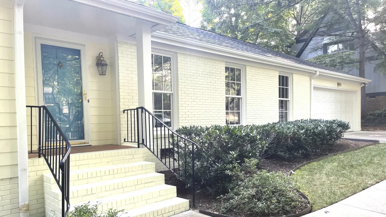 A yellow paint is used in painting an exterior of a house.