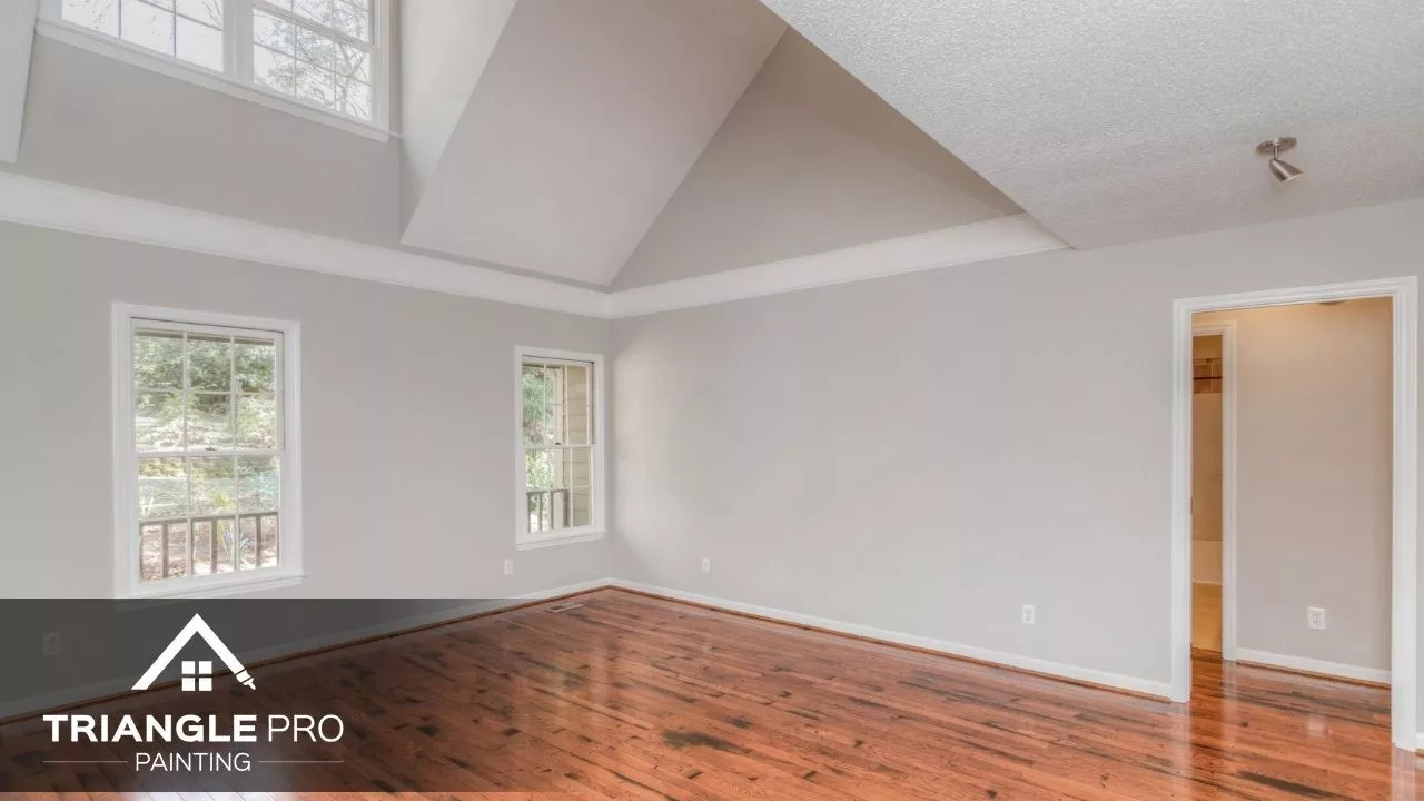 This is a spacious living room with vaulted ceiling and soft gray walls painted by Triangle Pro Painting in Umstead Raleigh NC.