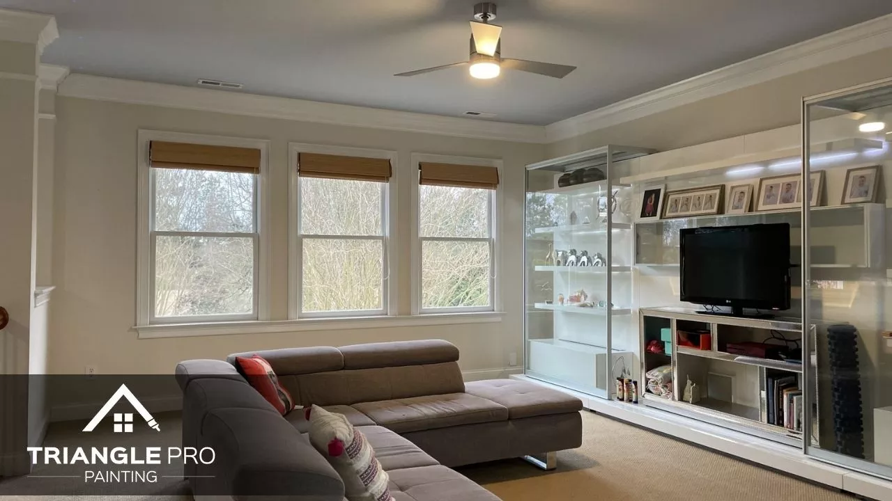 A cozy living room with soft neutral walls and detailed trim, painted by Triangle Pro Painting.