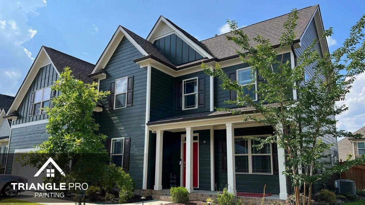 A bold and modern exterior with deep green siding and crisp white trim.