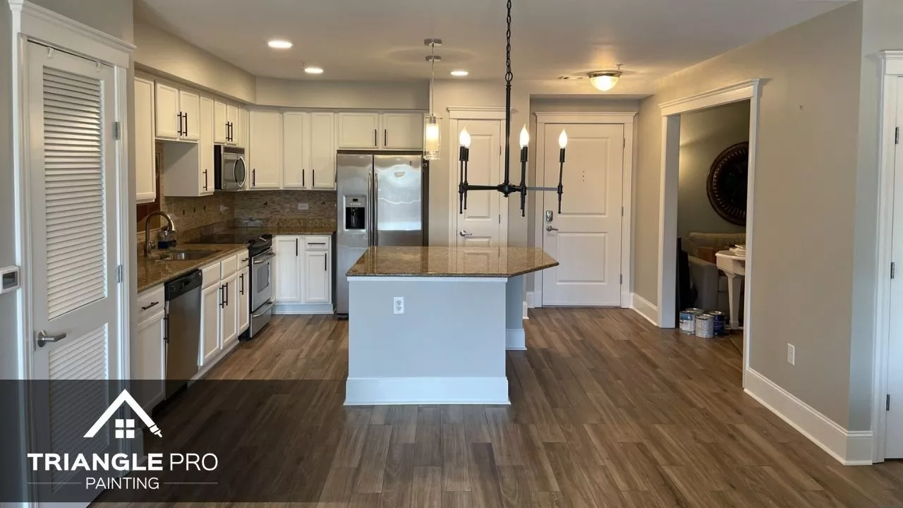This is an interior kitchen painting featuring white cabinets and neutral wall colors by Triangle Pro Painting in Wayland Heights Raleigh.