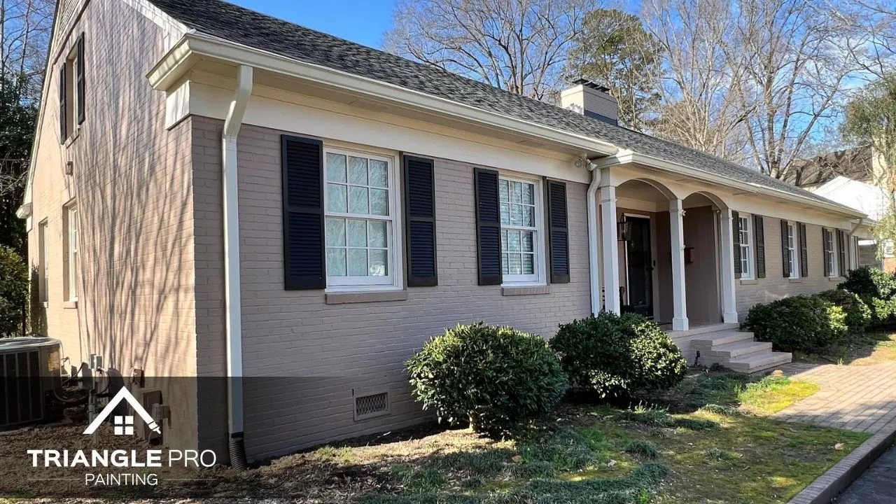 This is an exterior residential painting of a brick house with black shutters by Triangle Pro Painting in Wayland Heights Raleigh.
