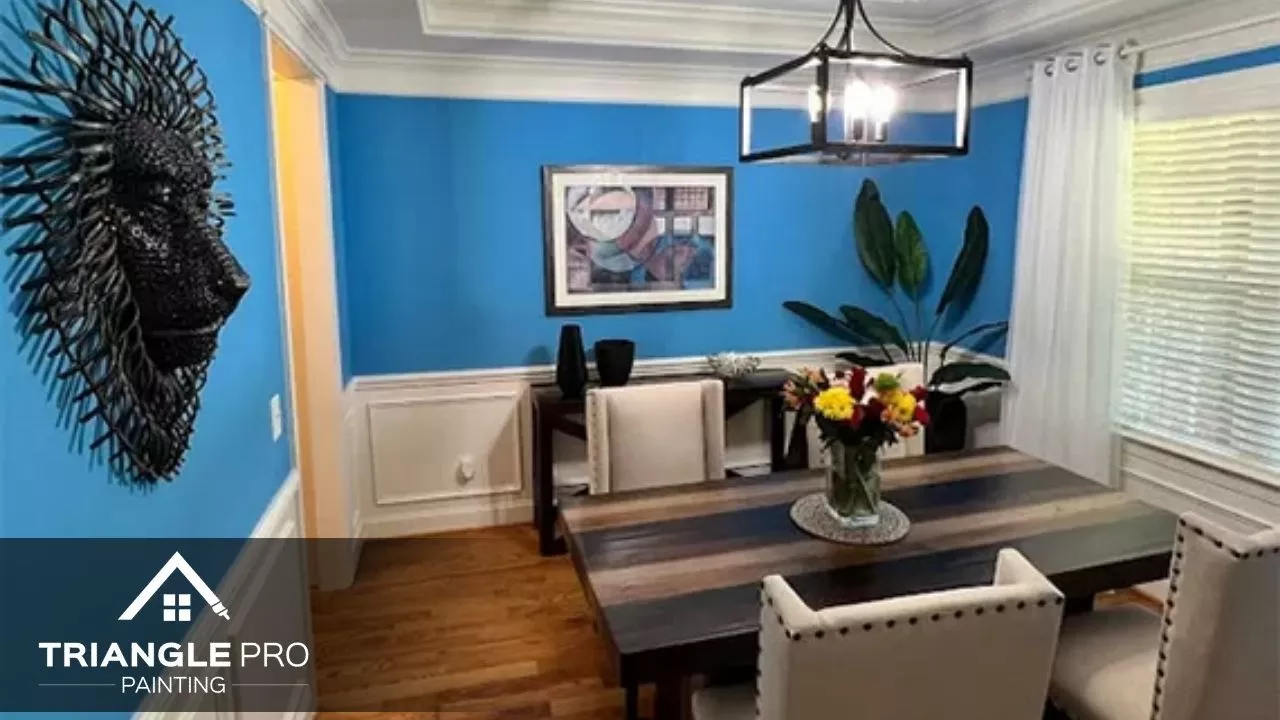 This is a bright blue dining room with white wainscoting painted by Triangle Pro Painting in Umstead Raleigh, NC.