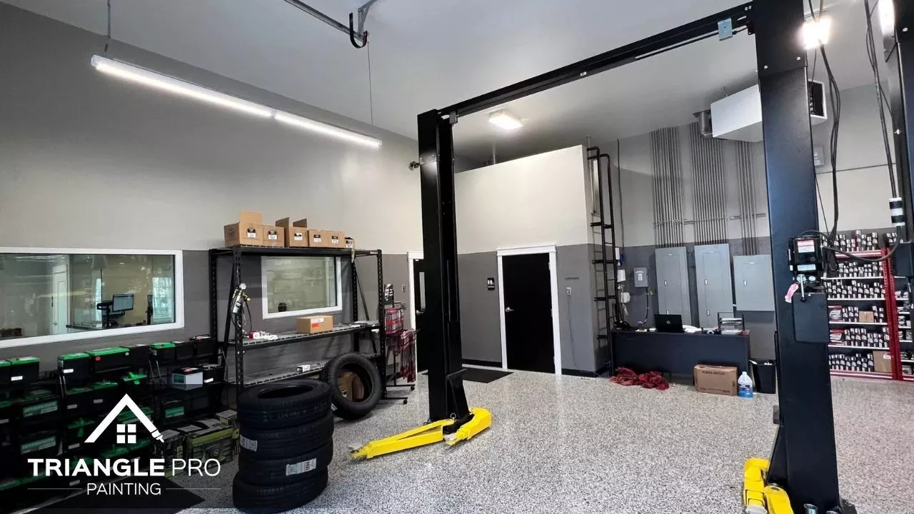 A clean and professionally painted auto repair shop interior by Triangle Pro Painting – featuring polished floors and sleek two-tone walls.