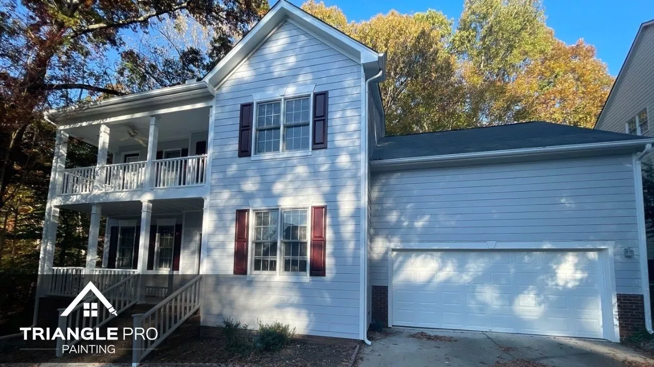 a refreshed light gray finish with white trim and maroon shutters.