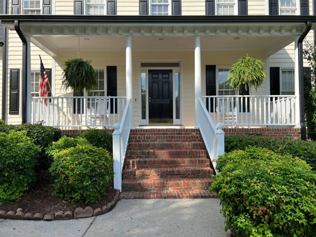 Painter applying moisture-resistant paint to a Raleigh home exterior