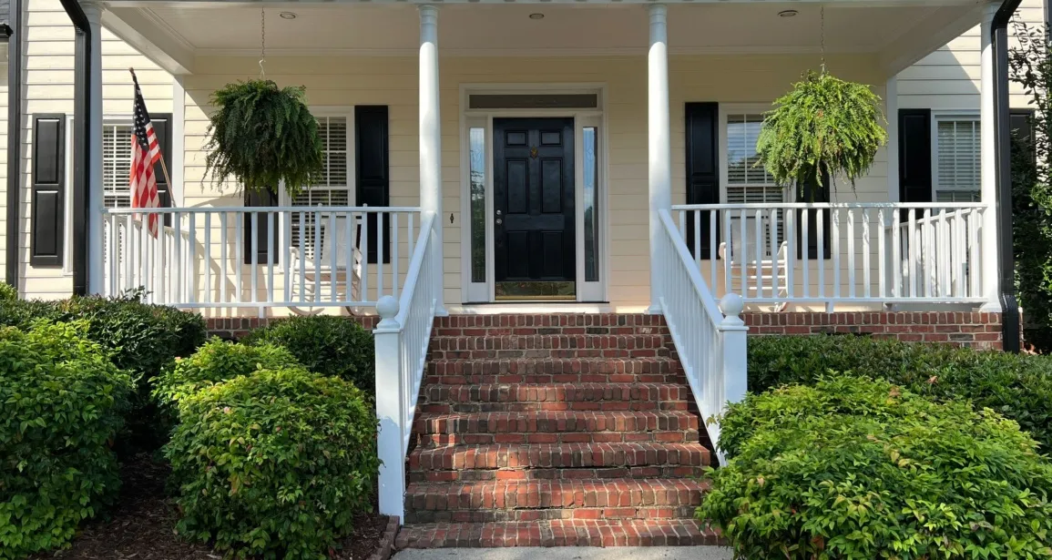 Painter applying moisture-resistant paint to a Raleigh home exterior