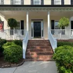 Painter applying moisture-resistant paint to a Raleigh home exterior