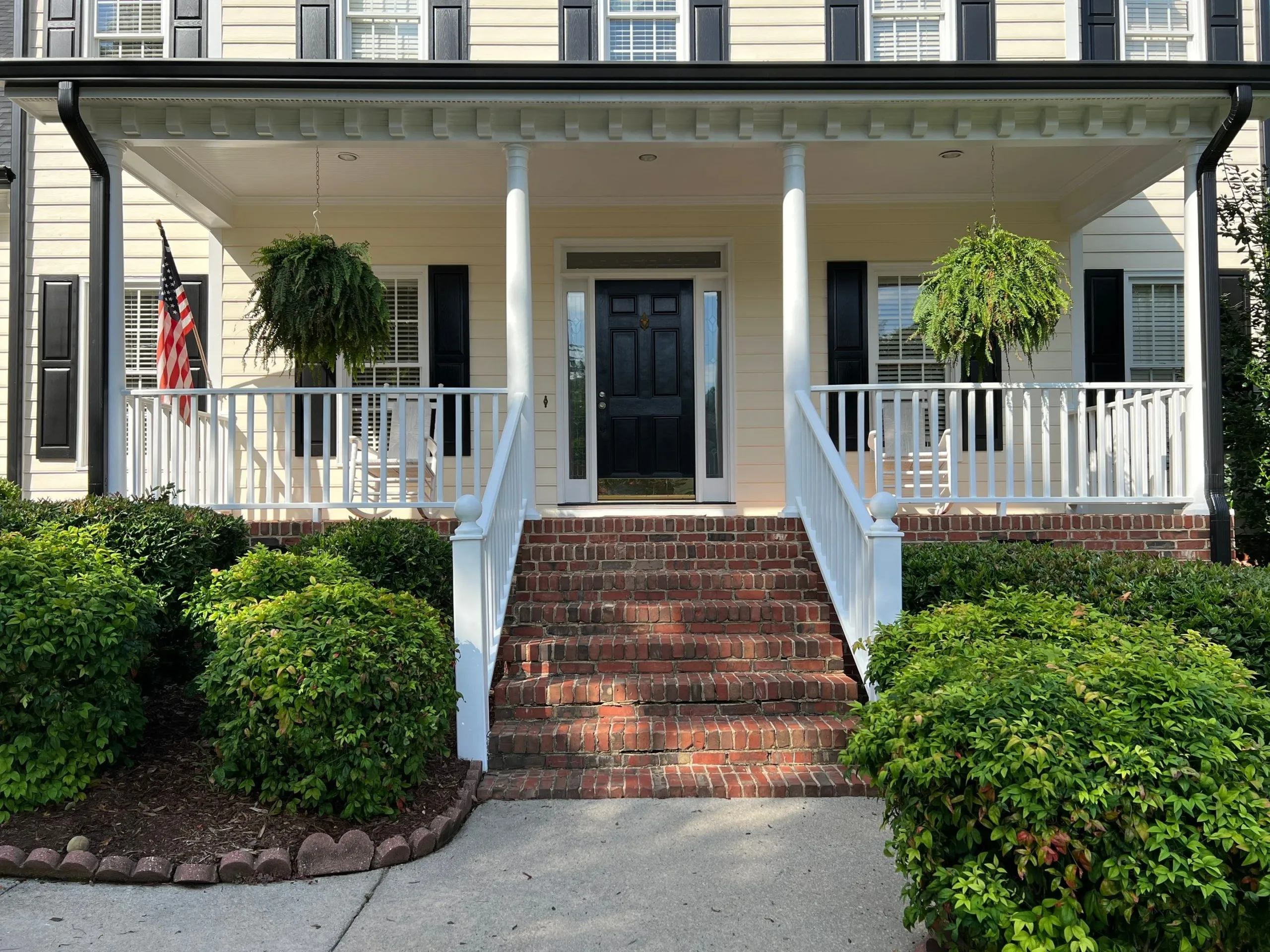 Painter applying moisture-resistant paint to a Raleigh home exterior